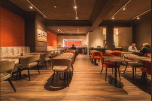 een restaurant met tafels en stoelen en mensen die aan tafels zitten bij Hotel Prado in Oostende