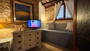 a bedroom with a bed and a television on a dresser at Residenza Teatro Antico in Todi