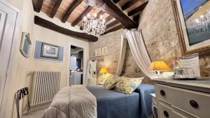 a bedroom with a blue bed and a chandelier at Residenza Teatro Antico in Todi