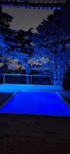 a blue swimming pool at night with trees in the background at NuestroSueño in Villa Serrana
