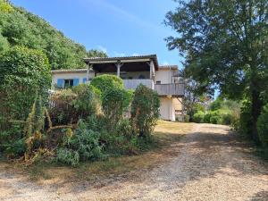 a house on a hill next to a dirt road at Clos des mimosas in Monflanquin