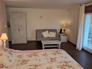 a bedroom with two beds and a couch and a window at Clos des mimosas in Monflanquin