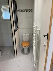 a bathroom with a toilet with a wooden seat at Gîte la pause en baie in Pendé +16 photos