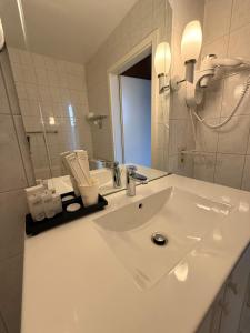 a white bathroom with a sink and a mirror at Chateau De Latour in Latour