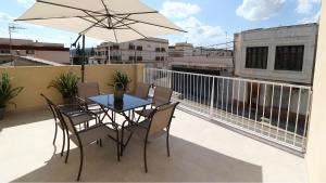 a table and chairs on a balcony with an umbrella at Niu Hostal in Casinos