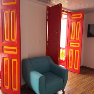 a living room with a blue chair and red doors at La Casa De Mi Tatis in Salento