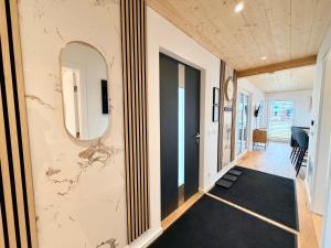 a hallway with a door and a mirror on the wall at Chalet du calme Gersthofen in Gersthofen