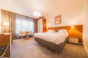 een hotelkamer met een bed en een bureau bij Hotel Prado in Oostende