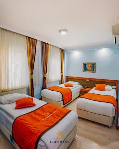 a hotel room with three beds with orange sheets at Hotel RABİS in Urfa +22 photos