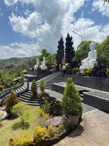 a group of white statues sitting on steps in a park at Family Hostel Lovina in Lovina