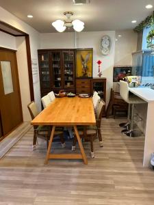 a dining room with a wooden table and chairs at 艶子の家 in Narashino