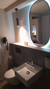 a bathroom with a sink and a mirror at Campanile NATURE -Haguenau in Haguenau