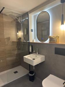 a bathroom with a sink and a shower with a mirror at Campanile NATURE -Haguenau in Haguenau