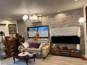 a living room with a couch and a flat screen tv at 艶子の家 in Narashino