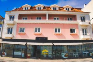ein großes rosa Gebäude mit einem Restaurant davor in der Unterkunft Hotel Nobu Peniche in Peniche + 12 Fotos