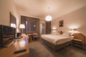 een hotelkamer met een bed en een flatscreen-tv bij Hotel Prado in Oostende