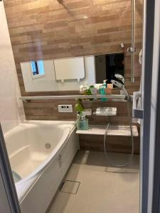 a bathroom with a bath tub and a sink at 艶子の家 in Narashino +11 photos