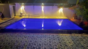 a blue swimming pool with a fountain in the background at SeekRide Bolgoda in Bandaragama
