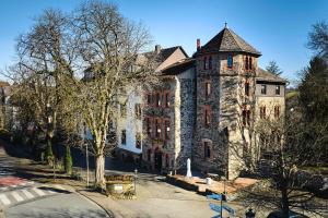 an old stone building with a tower on a street at Schlosshotel & Himmelreich Braunfels in Braunfels