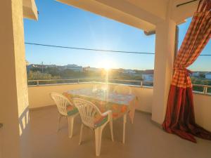 a table and chairs on a balcony with the sunset at Haus Ljubica Ražanac in Ražanac