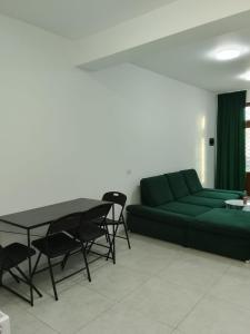 a living room with a green couch and a table at Focsani Casa cris in Focşani
