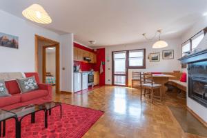 a living room with a red couch and a table at Condominio Meraviglia in Selva di Cadore