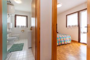 a bathroom with a toilet and a bed in a room at Condominio Meraviglia in Selva di Cadore +18 photos