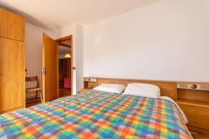a bedroom with a colorful bed with two pillows at Condominio Meraviglia in Selva di Cadore
