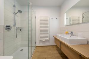 a bathroom with a sink and a glass shower at Villa Louisa - Wohnung 36 in Ostseebad Sellin +39 photos