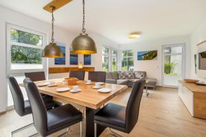 a dining room and living room with a wooden table and chairs at Villa Louisa - Wohnung 36 in Ostseebad Sellin