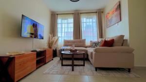 a living room with a couch and a tv at My Humble Abode - Machakos in Machakos