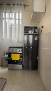 a kitchen with a stove and a microwave at My Humble Abode - Machakos in Machakos