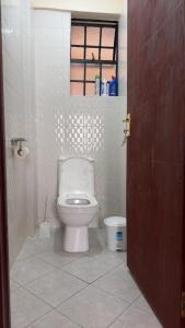a bathroom with a white toilet and a window at My Humble Abode - Machakos in Machakos +10 photos