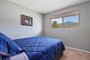 a bedroom with a blue bed and a window at The Brick House, Kellogg ID in Kellogg