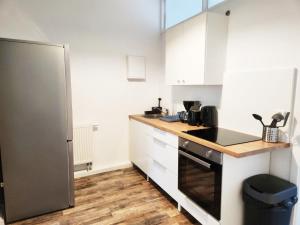 a kitchen with white cabinets and a stainless steel refrigerator at ST10-12 Monteurwohnung in Stolberg in Binsfeldhammer