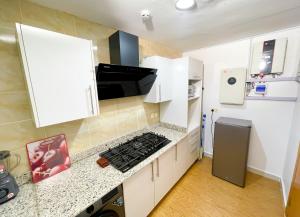 a kitchen with white cabinets and a stove top oven at LetMax Homes in Ikeja