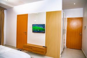 a bedroom with a tv on the wall and a bed at LetMax Homes in Ikeja