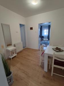 a white dining room with a table and chairs at Apartman LISA in Niš +23 photos