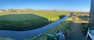 a boat is parked on the side of a river at Oomes Huus - Sleep by Hästens, Wake with Coffee in Den Hoorn
