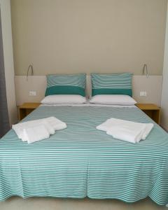 a blue and white bed with two pillows on it at Otium Mare Felix in Stazione di Paestum