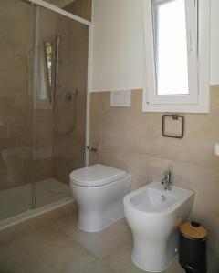 a bathroom with a toilet and a shower and a sink at Otium Mare Felix in Stazione di Paestum
