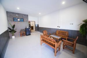 ein Wohnzimmer mit Holzbänken und einem Tisch und einem Tisch in der Unterkunft บ้านคุณ เฮ้าส์ in Phrae