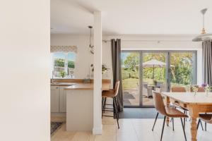 a kitchen and dining room with a table and chairs at Tokenhill Cottage in Dorchester