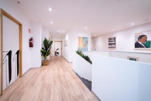 an empty hallway with white walls and wood floors at Koba Hostel in San Sebastián