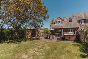 a backyard of a house with a tree at Tokenhill Cottage in Dorchester