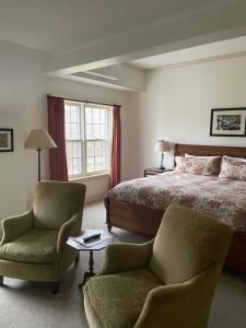 a bedroom with a bed and a chair and a table at The Old Lyme Inn in Old Lyme +93 photos