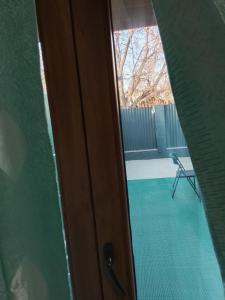 a door to a balcony with a chair in a room at Focsani Casa cris in Focşani
