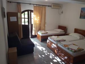 a room with two beds and a chair in it at Vila Stanisic in Čanj