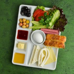 a plate of food with different types of cheese and vegetables at diamond premium hotel in Istanbul