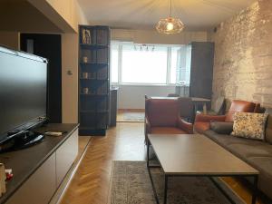 a living room with a couch and a tv at Катедрала Варна in Varna City